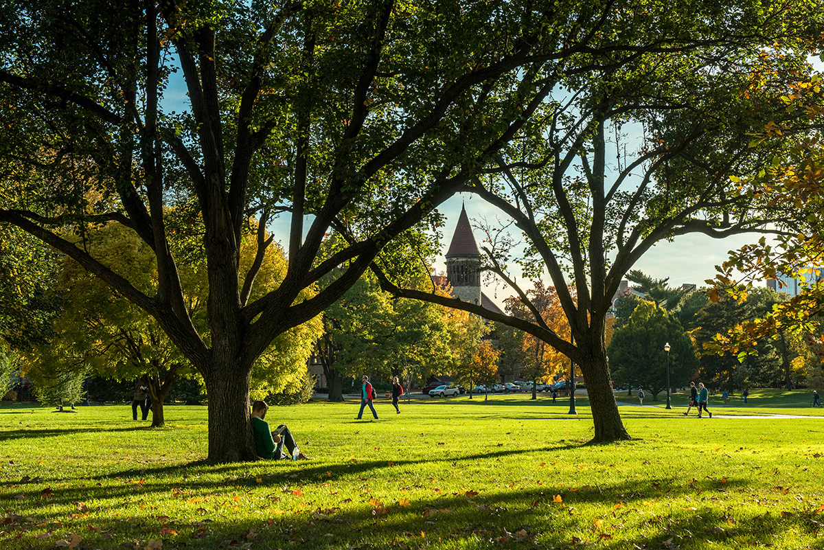 Students walk across the Oval as the Orton Hall bell tower is visible in the distance.