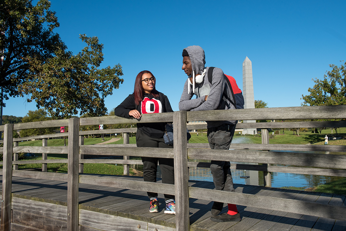 Two student stand on a bridge at Ohio State Newark.