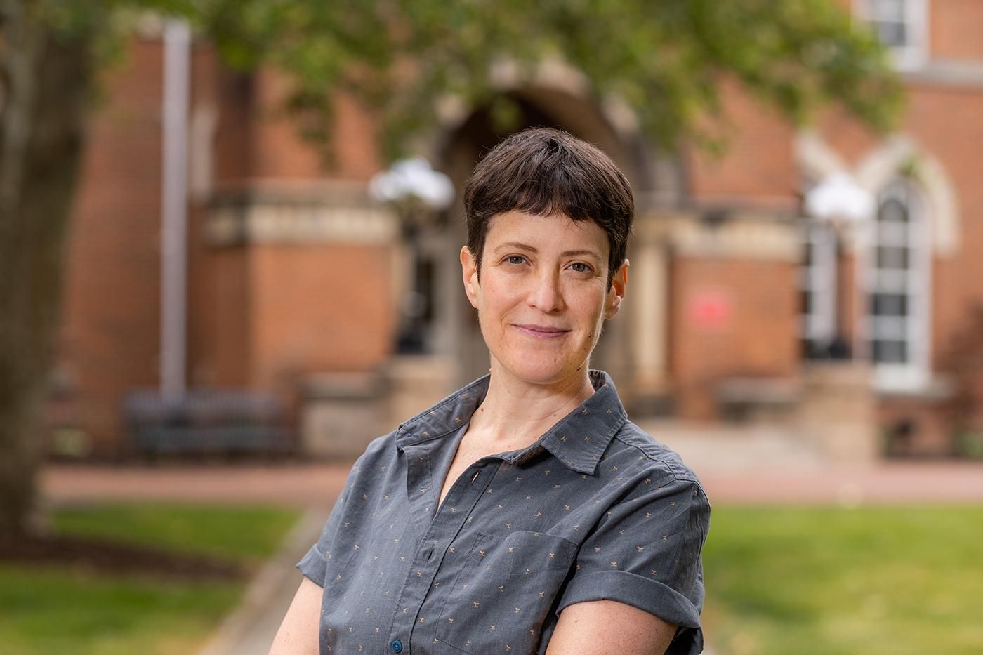 Headshot of Rin Reczek looking into the camera outside on campus