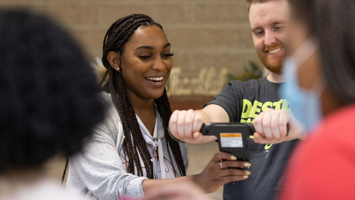 Faith Metlock smiles while speaking with colleagues at a community health event.