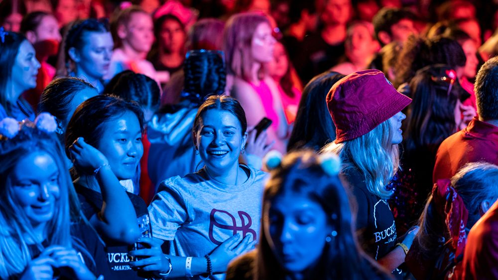 crowd of students in purple and pink concert lighting