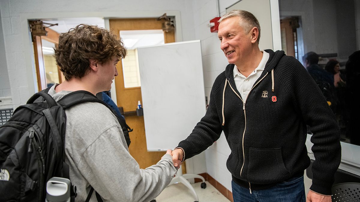 Ratmir Timashev, right, shakes hands with a student in an integrated business and engineering class.
