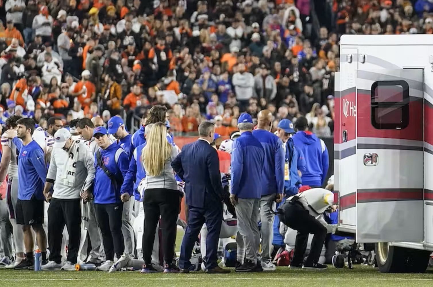 Players crowd around Damar Hamlin as he is transported onto an ambulance.