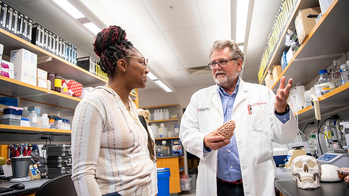 Dr. Krystof Bankiewicz speaking with another person in a medical facility