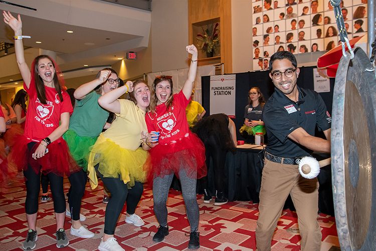 Imran Nuri ringing a BuckeyeThon bell as students cheer