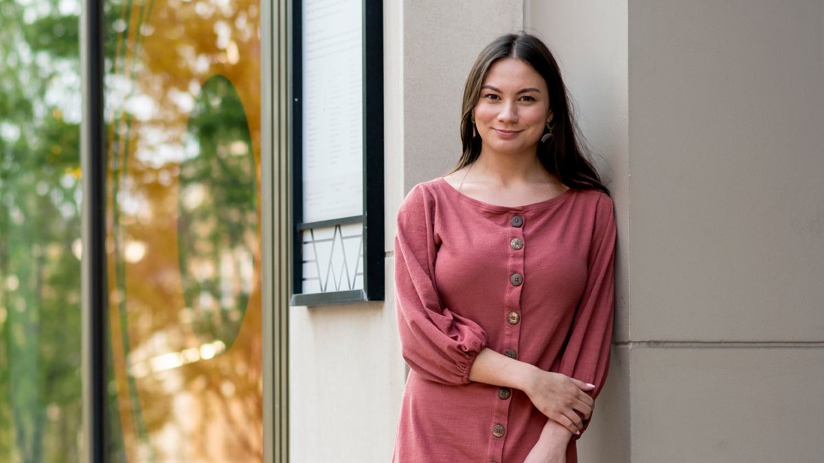 Naomi Kennedy leans against a building