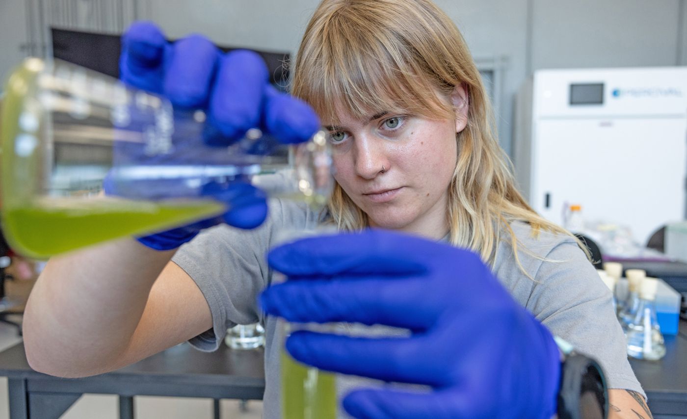 Ohio State student researcher Alex Kushnir pours a water sample into a test tube.