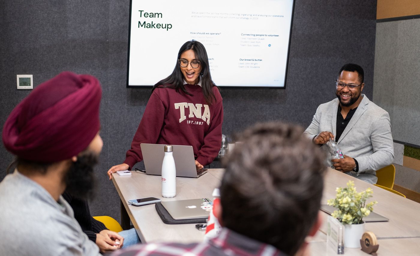 The ServUS team meets in a conference room.