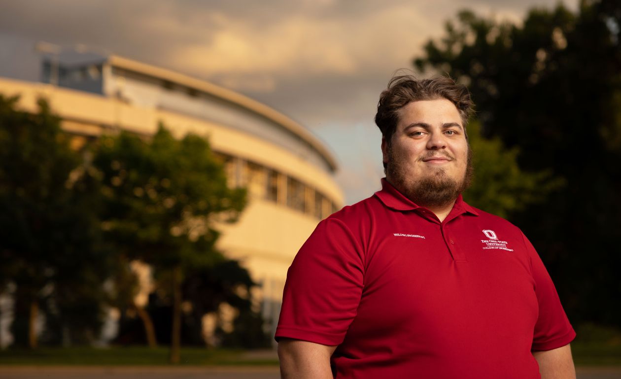 Sam Casto smiling in a red polo with Ohio Stadium in the background