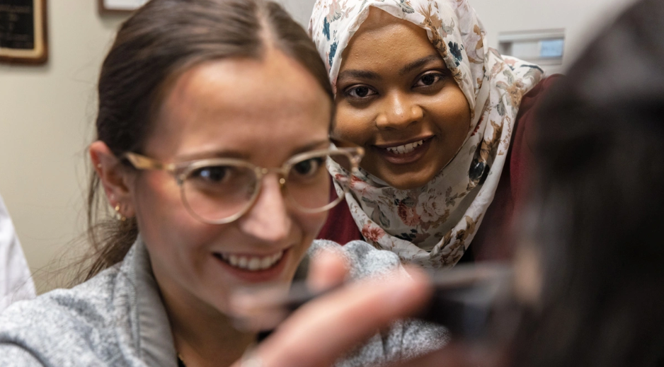 Dr. Mawada Osman looks on as optometry student Sidney Parks takes eye measurements.