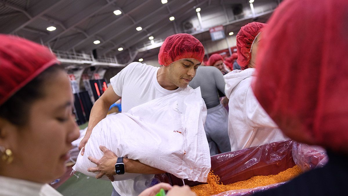 Alberto Casas pours food into a container.