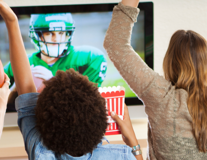 A woman and a child cheer in reaction to a football game.