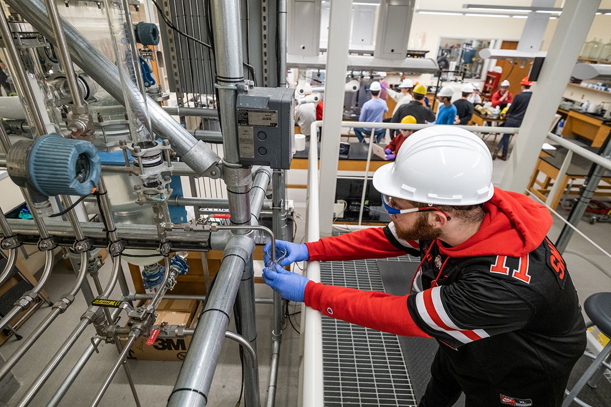 An engineering works on a piece of equipment in a lab at Ohio State