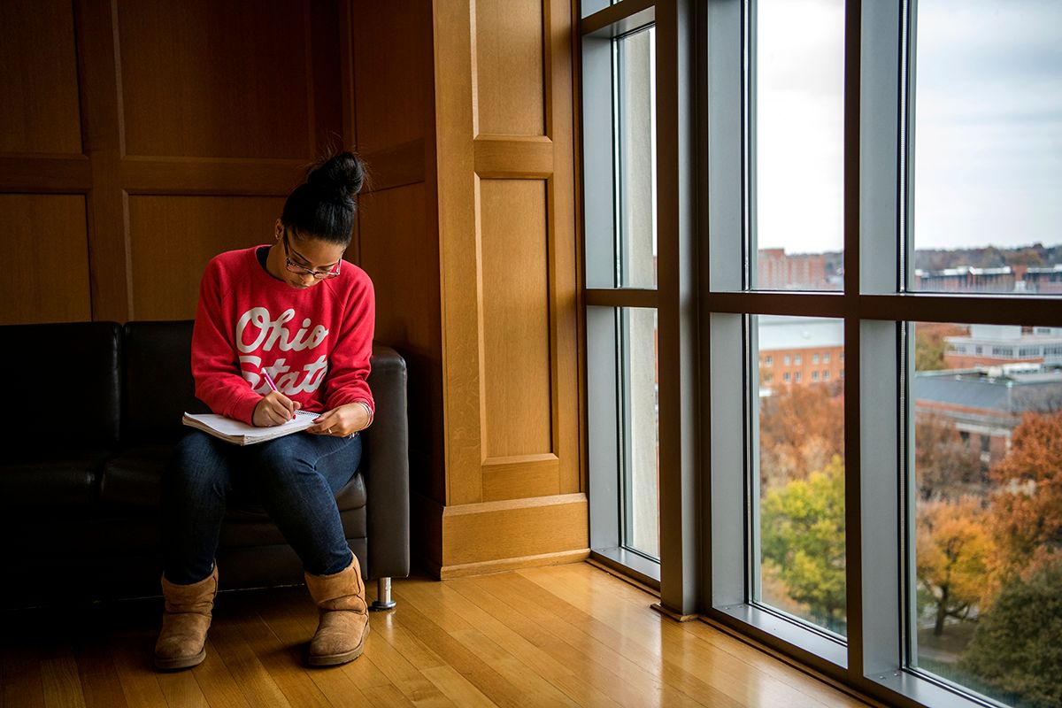 A student studies in front a window in a study space on the top floor of Ohio State's Thompson Library.