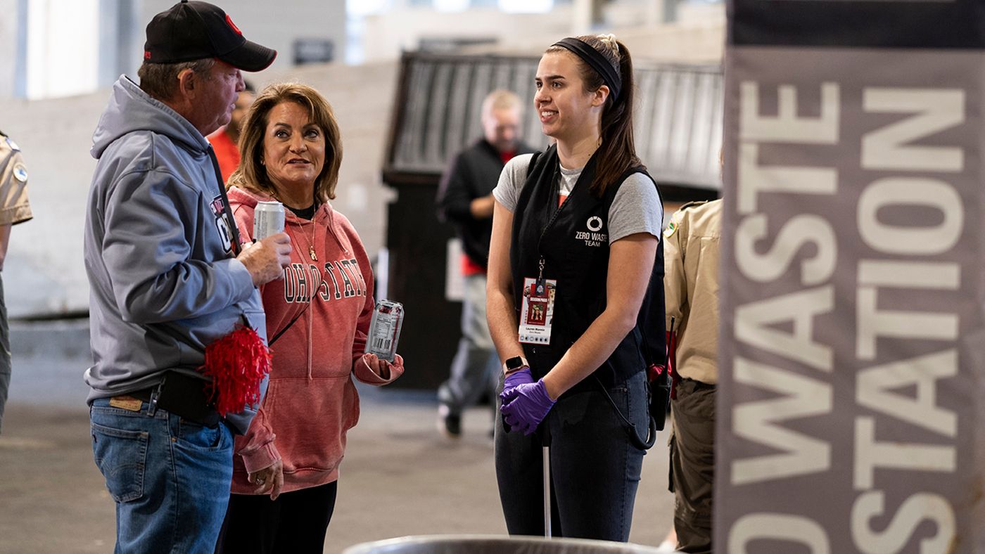 An Ohio State student talks to two people at Ohio Stadium about the Zero Waste project.