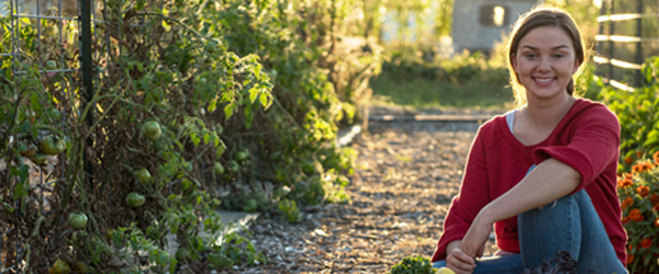 Maggie Griffin kneeling in a vegetable garden