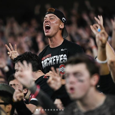 excited fan cheers at a night game