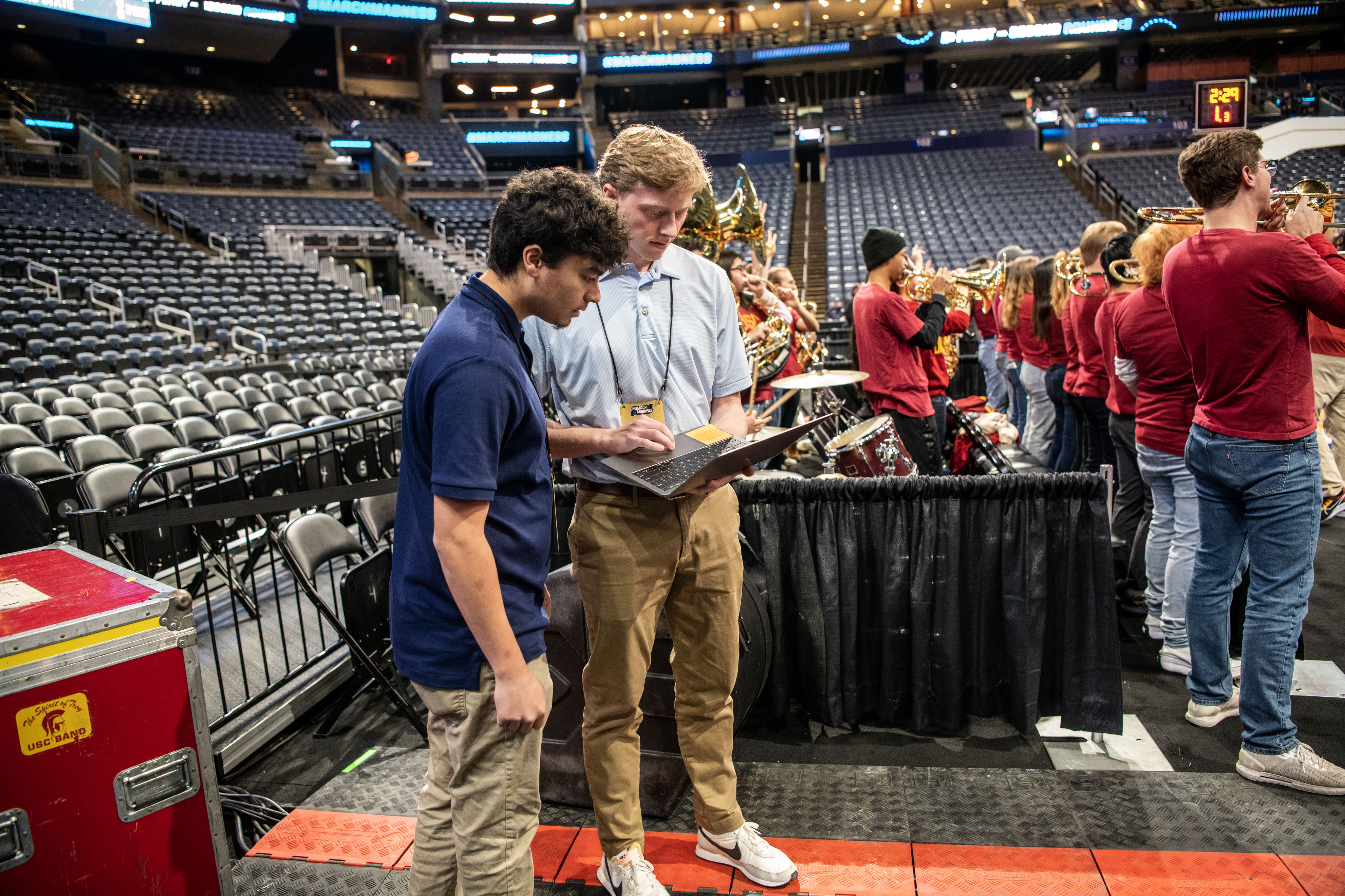 Students Gabe Payne and Jack Weller holding a laptop and preparing for their work on the floor of Nationwide Arena.